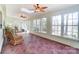 Bright sunroom with terracotta tile floor, ceiling fan, and abundant windows at 1300 Old Farm Rd, Charlotte, NC 28226