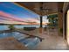Covered patio with hot tub, pool, and serene lake view at 132 Rollingwood Ln, Mooresville, NC 28117