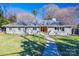 Gray brick ranch home with double wood doors, landscaped lawn, and walkway at 2861 Sharon Rd, Charlotte, NC 28211