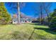 Gray brick home with a landscaped yard and mature trees at 2861 Sharon Rd, Charlotte, NC 28211