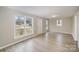 Bright living room with light gray walls, wood-look floors, and access to other rooms at 433 Greenwood Dr, Charlotte, NC 28217