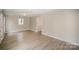 Bright living room with light gray walls, wood-look floors, and access to other rooms at 433 Greenwood Dr, Charlotte, NC 28217