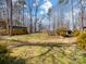 Spacious backyard with mature trees, green grass, and a storage shed in a serene outdoor setting at 4465 Red Hill Cir, Denver, NC 28037