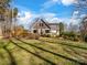 Back exterior of house and yard with a blend of natural beauty and well-maintained landscaping at 4465 Red Hill Cir, Denver, NC 28037