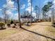 Charming two-story home with a brown roof, white siding, and a large front yard with mature trees and a carport at 4465 Red Hill Cir, Denver, NC 28037