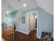 Hallway leading to rooms featuring hardwood floors, blue accent wall paint and natural lighting at 4465 Red Hill Cir, Denver, NC 28037
