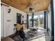 Bright home gym with wood ceiling, exercise bike, treadmill and sliding glass doors to the outside deck at 4465 Red Hill Cir, Denver, NC 28037