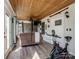 Cozy home gym with a wood ceiling, featuring a TV and comfortable seating with outdoor access at 4465 Red Hill Cir, Denver, NC 28037