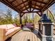 Covered outdoor living space featuring wicker sofas, coffee table and a stone fireplace at 4465 Red Hill Cir, Denver, NC 28037