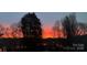 Picturesque sunset view with tree silhouettes framing a stunning orange and pink sky over a serene lake at 4465 Red Hill Cir, Denver, NC 28037