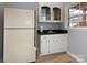 Small basement kitchenette with white cabinets and a refrigerator at 6742 Constitution Ln, Charlotte, NC 28210