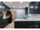 Modern kitchen with dark cabinetry, stainless steel appliances, and a breakfast bar at 6800 April Ln, Charlotte, NC 28215