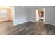 Open living space with gray walls, laminate floors, and views to dining and stairs at 6800 April Ln, Charlotte, NC 28215