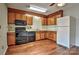 Functional kitchen design featuring wood cabinetry, appliances, and hardwood flooring at 8316 Rust Wood Pl, Charlotte, NC 28227