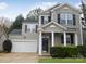 Two-story house with gray siding, a white garage door, and landscaping at 8540 Filbert Ln, Charlotte, NC 28215