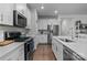 Modern kitchen with white cabinets, quartz countertops, and stainless steel appliances at 8932 Pennegrove Cir, Charlotte, NC 28214