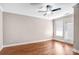 Bedroom with hardwood floors, ceiling fan, and door to balcony at 1000 E Woodlawn Rd # 105, Charlotte, NC 28209