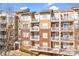 Brick building with multiple units, private balconies, and ample parking at 1000 E Woodlawn Rd # 105, Charlotte, NC 28209