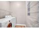 Laundry room with washer, dryer, and storage shelves at 1000 E Woodlawn Rd # 105, Charlotte, NC 28209
