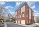 Side view of three-story townhome showcasing brick exterior and garage at 106 N Laurel Ave # 120, Charlotte, NC 28207