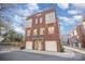 Three story townhome with white garage doors and brick facade at 106 N Laurel Ave # 120, Charlotte, NC 28207