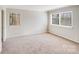 Well-lit bedroom with carpet flooring and two windows at 1213 Jules Ct, Charlotte, NC 28226