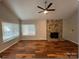 Spacious living room featuring hardwood floors, stone fireplace, and abundant natural light at 1213 Jules Ct, Charlotte, NC 28226