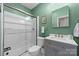 Modern bathroom with glass shower, gray vanity, and green walls at 12466 Preservation Pointe Dr, Charlotte, NC 28216