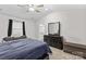 Spacious bedroom with a large bed, dresser, and ceiling fan at 140 Colonial Reserve Ave, Troutman, NC 28166