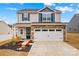 Two-story house with gray siding, stone accents, and a two-car garage at 140 Colonial Reserve Ave, Troutman, NC 28166