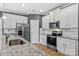 Modern kitchen with white cabinets, granite countertops, and stainless steel appliances at 140 Colonial Reserve Ave, Troutman, NC 28166