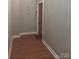 Simple hallway with wood flooring and a red door at 201 S Hoskins Rd # 136, Charlotte, NC 28208