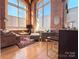 Living room with hardwood floors, exposed brick, and large windows at 201 S Hoskins Rd # 136, Charlotte, NC 28208