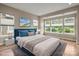 Relaxing bedroom with lots of natural light, a large bed, a side table with lamps, and a beach-themed wall decoration at 253 Stone Mountain Way, Denver, NC 28037