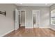 Open bedroom with hardwood flooring, recessed lighting, open doors to storage, and a window at 253 Stone Mountain Way, Denver, NC 28037