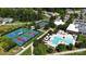 Aerial view of a community pool and tennis courts surrounded by lush greenery and well-maintained landscaping at 253 Stone Mountain Way, Denver, NC 28037