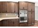 Close up of the kitchen's stainless steel wall ovens and custom cabinetry with countertop at 253 Stone Mountain Way, Denver, NC 28037