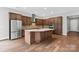 Contemporary kitchen boasts stainless steel appliances, center island with seating, and stylish wooden cabinetry at 253 Stone Mountain Way, Denver, NC 28037