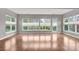 Empty living room with large windows overlooking the backyard and hardwood flooring at 253 Stone Mountain Way, Denver, NC 28037