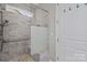Modern shower features gray tiled walls, built-in bench, shower heads, pebble flooring, and a frosted glass partition at 253 Stone Mountain Way, Denver, NC 28037