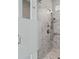 Modern shower with gray-tiled walls, pebble flooring, frosted glass partition, and sleek fixtures at 253 Stone Mountain Way, Denver, NC 28037