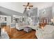 Bright living room featuring hardwood floors, vaulted ceilings, and an open floor plan to the kitchen and staircase at 3115 Duck Point Dr, Monroe, NC 28110