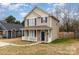 Two-story tan house with white porch and blue door, located on a tree-lined street at 3249 Ian Patrick Ave, Kannapolis, NC 28083