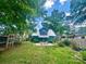 Large backyard with lush lawn, mature trees, and a charming chicken coop, perfect for outdoor enjoyment at 3317 Ritch Ave, Charlotte, NC 28206