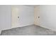 Empty bedroom showcasing neutral carpet, base molding, and two entry doors at 3317 Ritch Ave, Charlotte, NC 28206