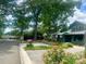Green two-story house with a covered porch surrounded by lush greenery and landscaping at 3317 Ritch Ave, Charlotte, NC 28206