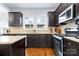 Modern kitchen with dark cabinets, granite countertops, stainless steel appliances, and hardwood floors at 3317 Ritch Ave, Charlotte, NC 28206