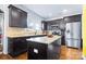 Open kitchen featuring a center island, stainless steel appliances, dark cabinetry and hardwood floors at 3317 Ritch Ave, Charlotte, NC 28206