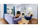 Bright living room featuring a stylish lavender sofa, area rug, and a white painted brick fireplace at 3317 Ritch Ave, Charlotte, NC 28206