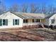 Ranch home with metal roof, green shutters, and stone walkway at 9409 Indian Trail Fairview Rd, Indian Trail, NC 28079